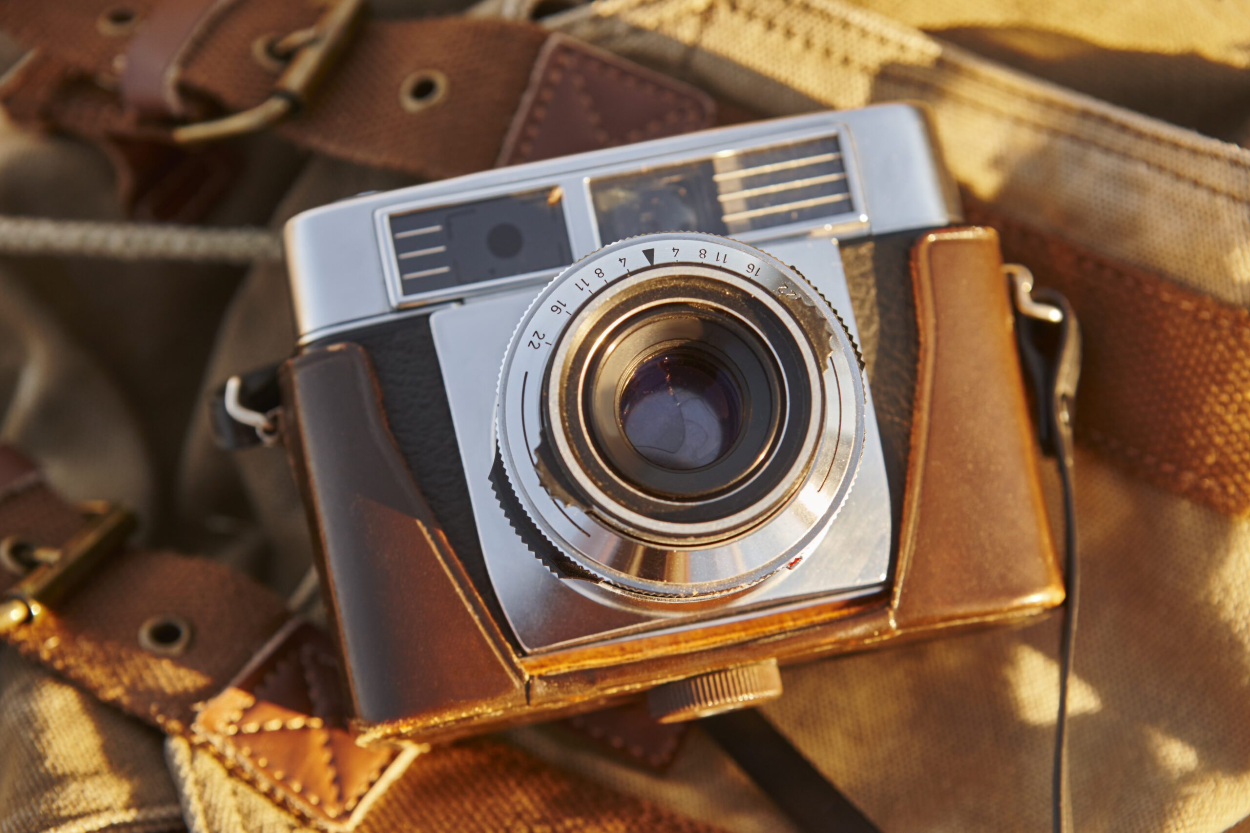 Vintage camera with backpack at dawn. Travel background